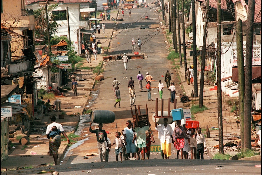 A Liberian family takes home furniture in April 1996