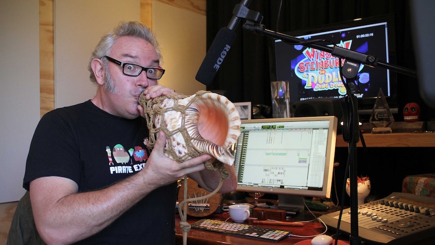 Oscar winning sound engineer Nigel Christensen blows into a conch in his studio.