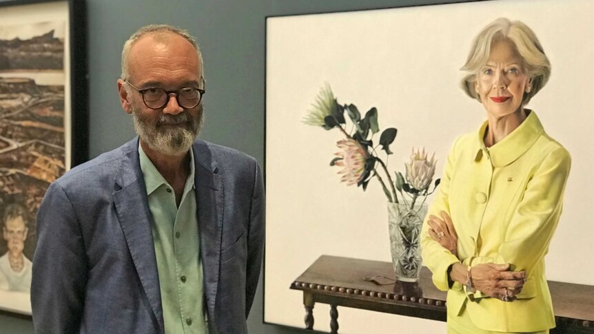 Angus Trumble standing in front of a portrait of Quentin Bryce.