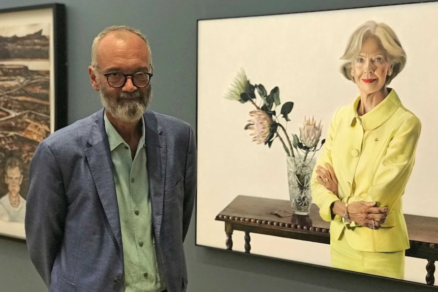 Angus Trumble standing in front of a portrait of Quentin Bryce.