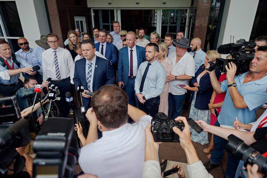 media surround two men in front of microphones