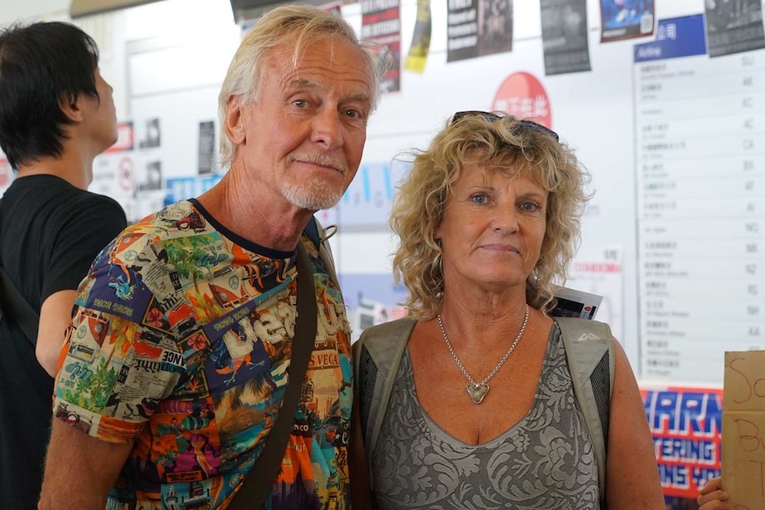 A man and a woman stand side by side for a photo