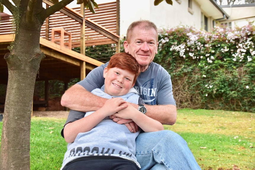 11-year-old Jacob James shares a hug with his dad Pete to depict family life with a father with younger onset dementia.