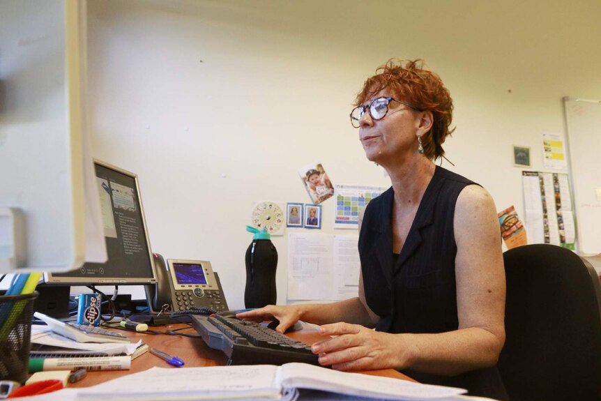 A photo of researcher Fiona Shalley sitting at her desk in a university.