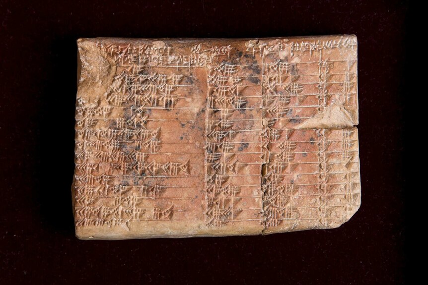 A closeup of a clay tablet covered in cuneiform script.
