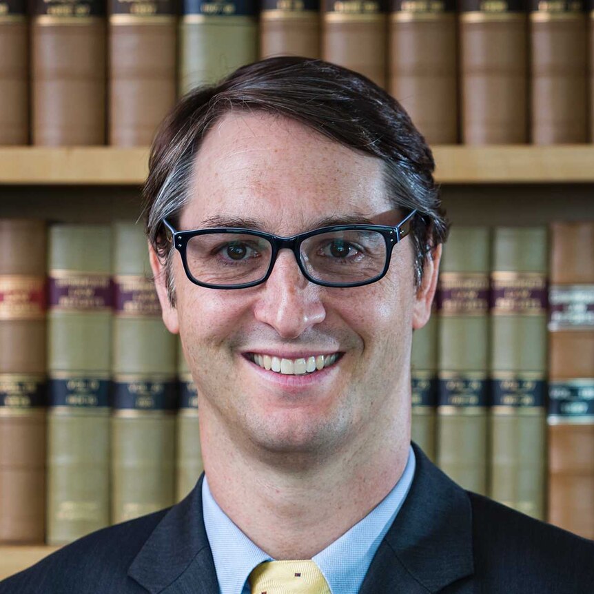 Official portrait of Justice James Edelman in front of a bookcase.