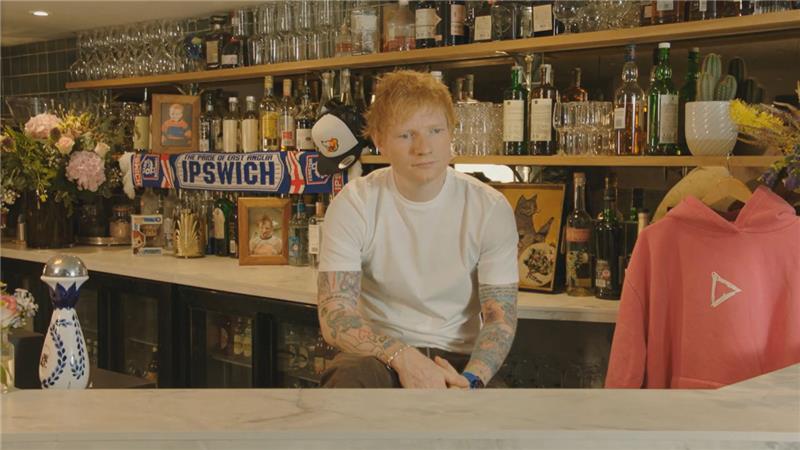  A man wearing a white top sitting behind a bar
