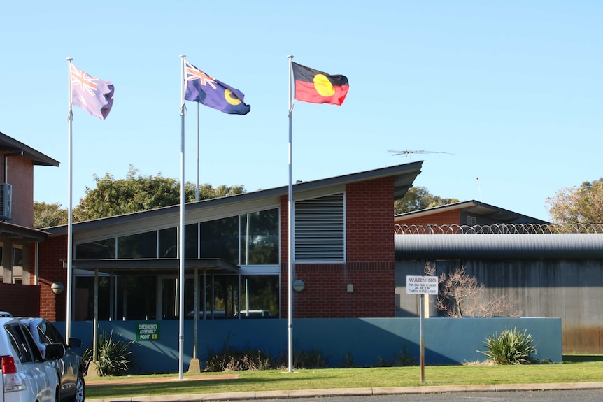 Three flags flying outside the entrance to the Banksia Hill Detention Centre.