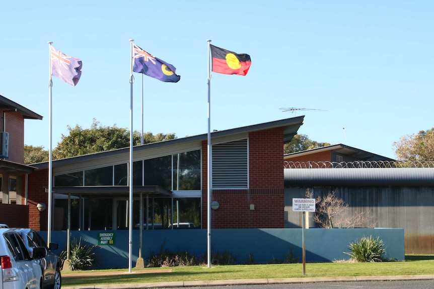 A building in a rural town with flags flying outside it