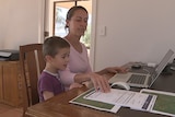 Anna Shaw at a laptop with her son.