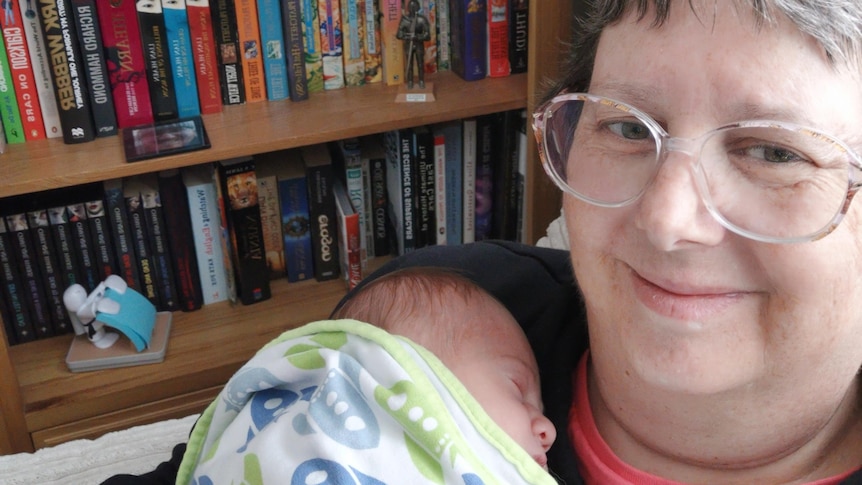 Joanne Cowan holds her newborn grandson Alex to her chest during a visit to the United Kingdom. 