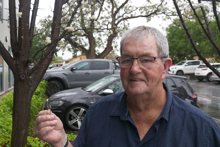 An older man holding a single drink can ring-pull.