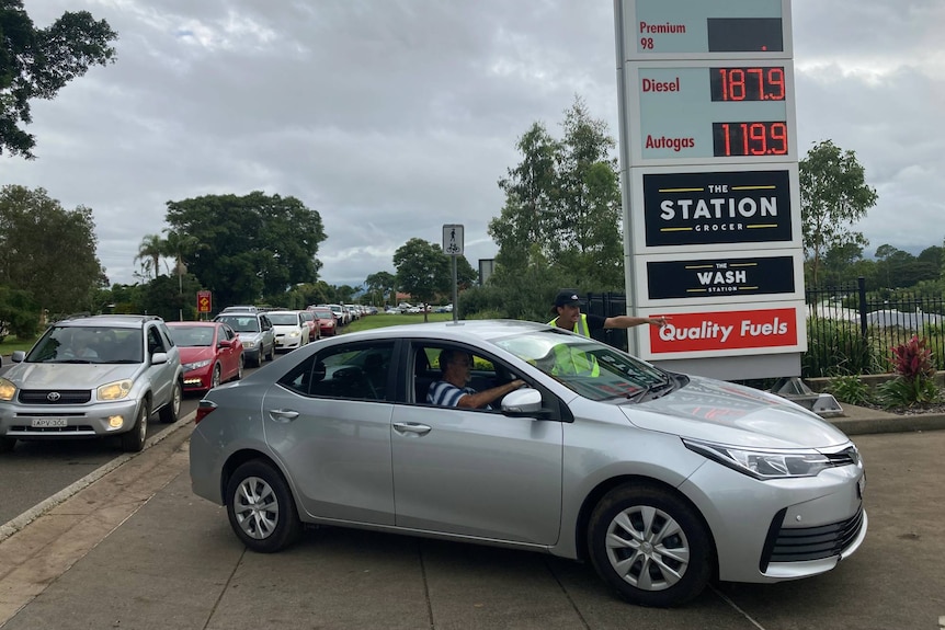 A long line of cars waiting to get fuel at a petrol station