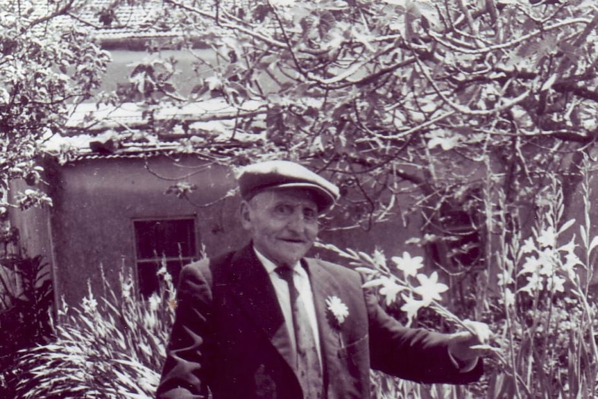 An old photo of a man holding a flower