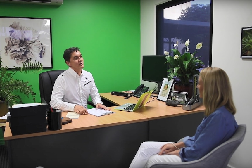 Doctor sits with patient at desk in clinic