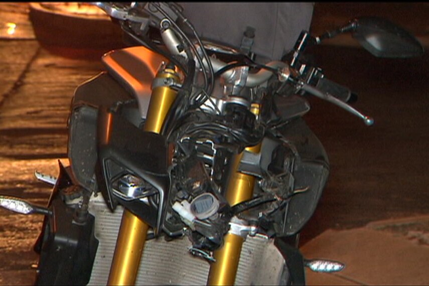 A damaged headlight on the front of a black motorcycle