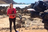 Amy Taeuber doing a piece to camera by the ocean for Channel 7