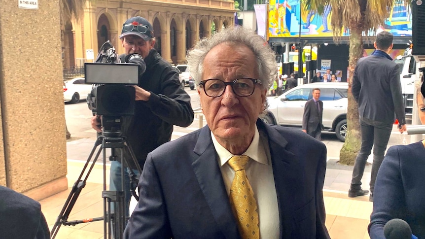 Geoffrey Rush looking concerned arriving at court.