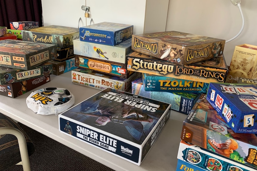 trestle table stacked with board games