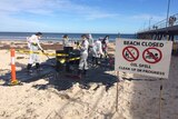 Protesters create a fake oil spill on Glenelg Beach.