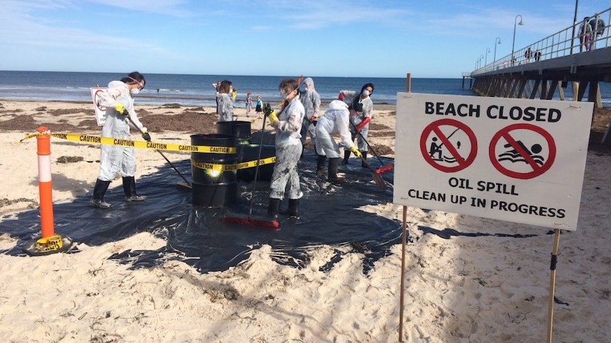 Protesters create a fake oil spill on Glenelg Beach.