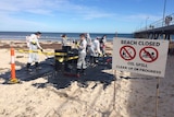Protesters create a fake oil spill on Glenelg Beach.