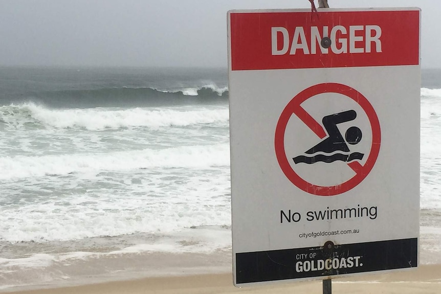 Rough waves and don't swim sign on Queensland's Gold Coast beach during wild weather on February 12, 2020.