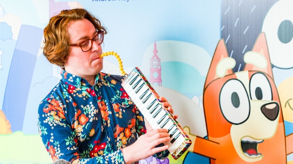 A man in a colourful shirt plays the melodica