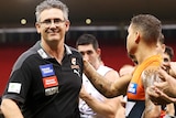 Leon Cameron smiles as he walks off through a guard of honour made by Giants players