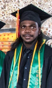 A cropped photo of an Aboriginal man in a graduation cap and gown