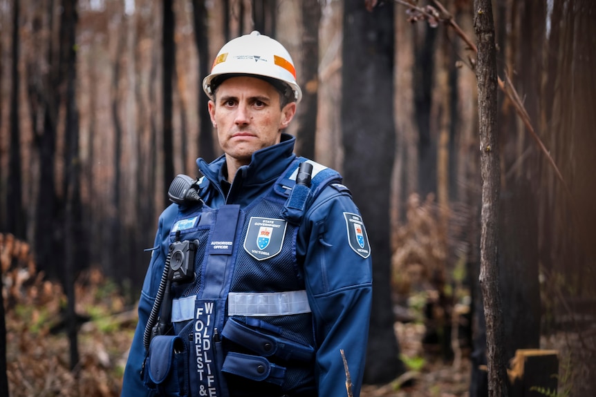 Brady Childs, authorised officer with the Conversation Regulator, pictured in a burnt-out forest. 