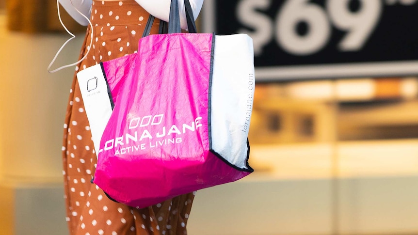 A woman holding a Lorna Jane bag.