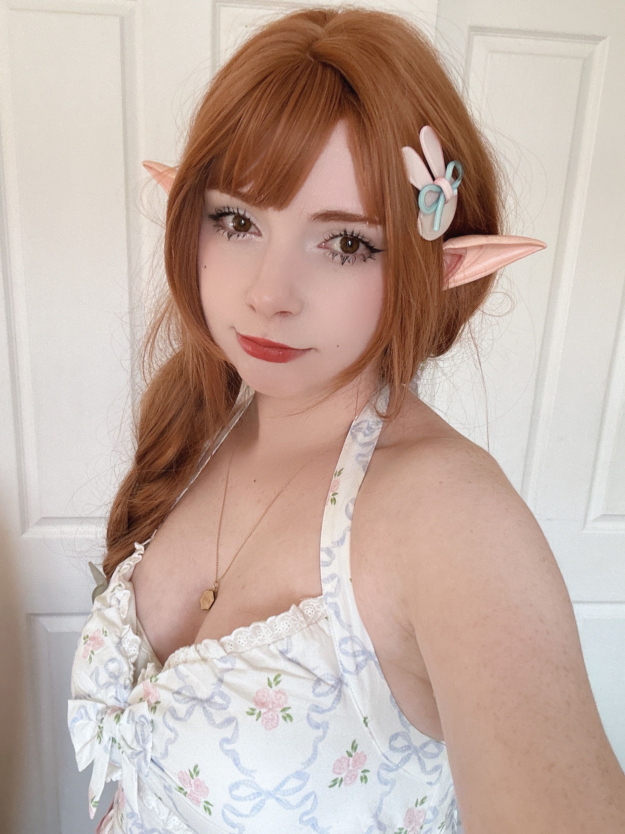 Un primer plano del rostro de una mujer. Tiene el pelo castaño rojizo y lleva orejas de elfo. 