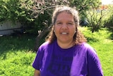 Karina Lester smiles at the camera while standing in the sun.