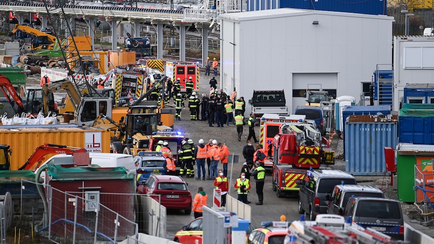 Firefighters, police officers and railway employees are seen at a railway site