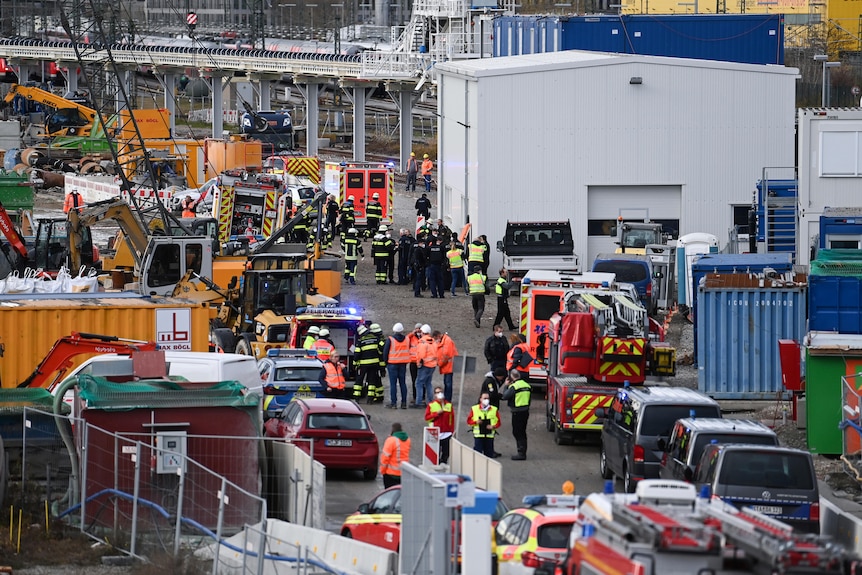 Firefighters, police officers and railway employees are seen at a railway site