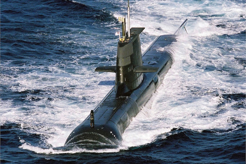 Aerial view of HMAS Sheean ploughing throw the waves.