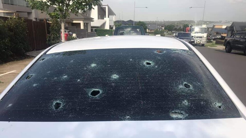 A car window with holes caused by hail
