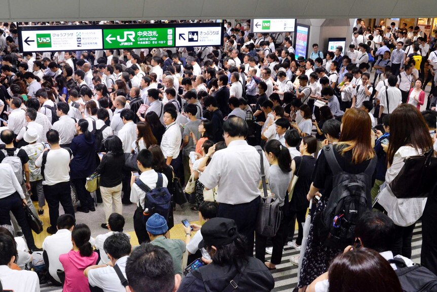A Tokyo train station is packed with commuters delayed by the typhoon.