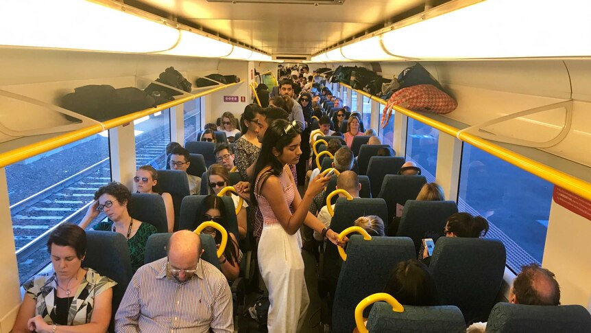 Passengers onboard an overcrowded morning peak V/Line train service from Geelong to Melbourne.