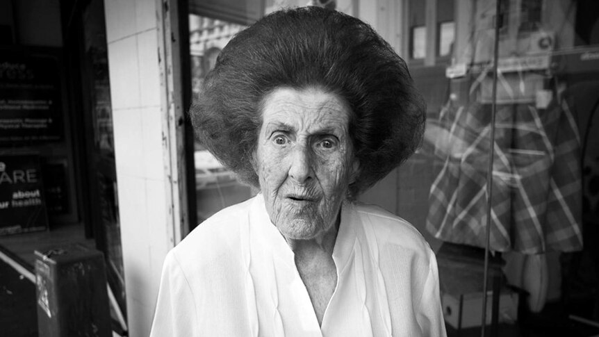 An elderly woman with a bouffant hairdo.