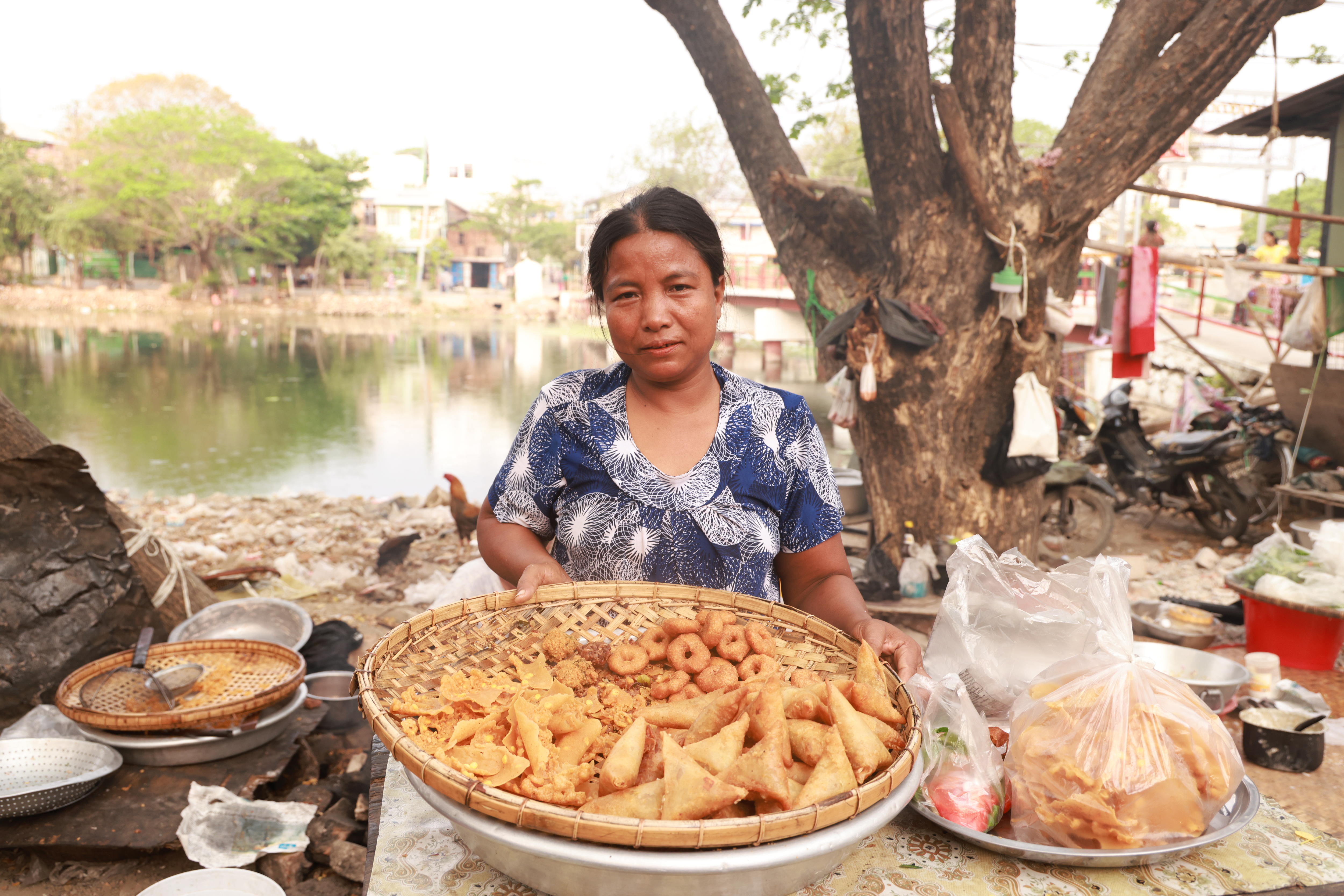 woman holds a basket of fried goods.