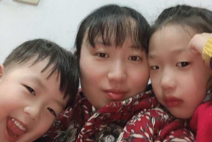 A selfie of a woman and her two children.