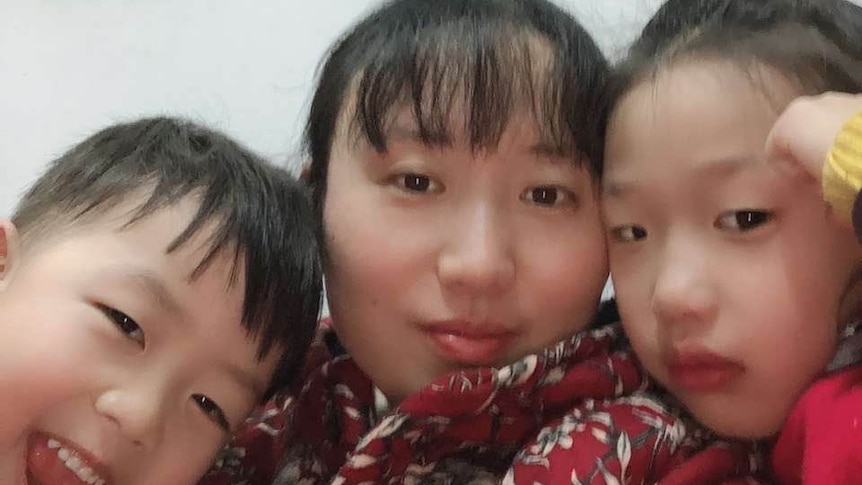 A selfie of a woman and her two children.