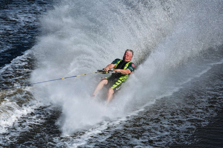 A man pulls one foot off the water on the Torrens