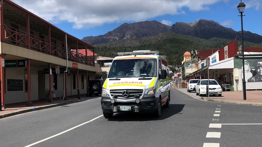 An ambulance in the main street of Queenstown, in Tasmania's west, with Mount Lyell in the background