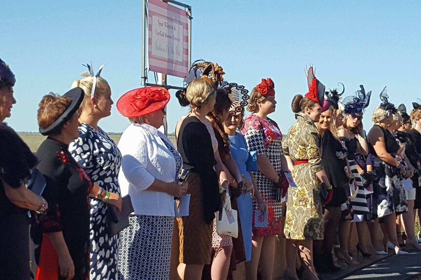Women in racewear lined up for judging in Corfield's Fashions on the Field.
