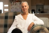 A woman reclines in a chair.