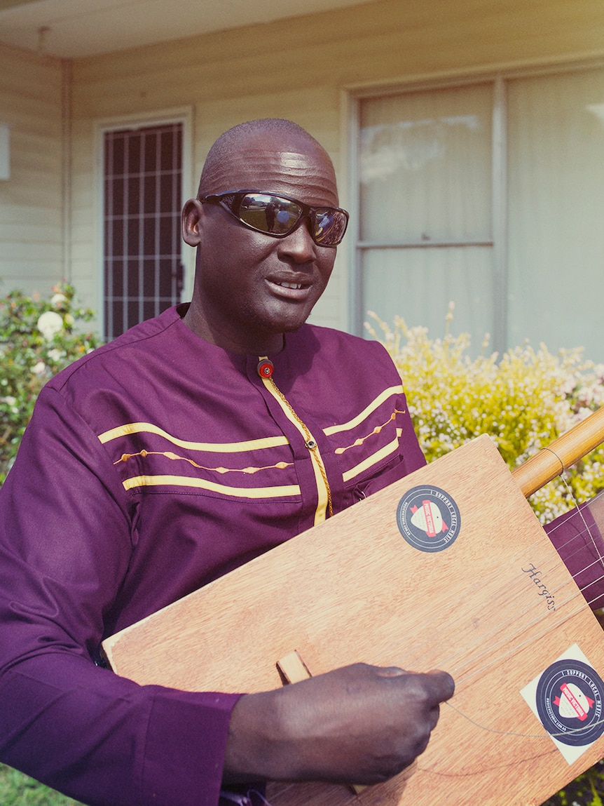 Gordon Koang holds a thom, a traditional Nuer instrument