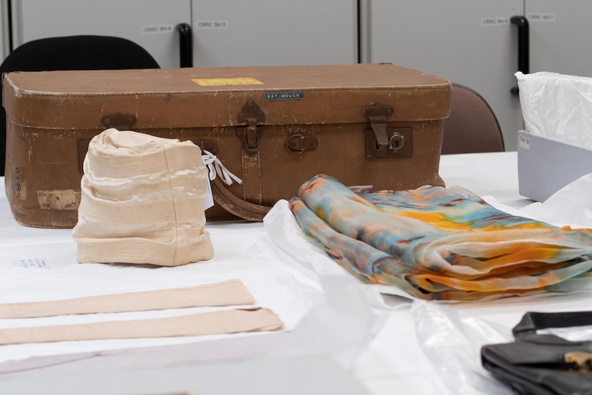 Gay Welch's hat, suitcase, gloves and scarf set out on a table.